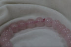 Pink beaded bracelet on a light fabric background