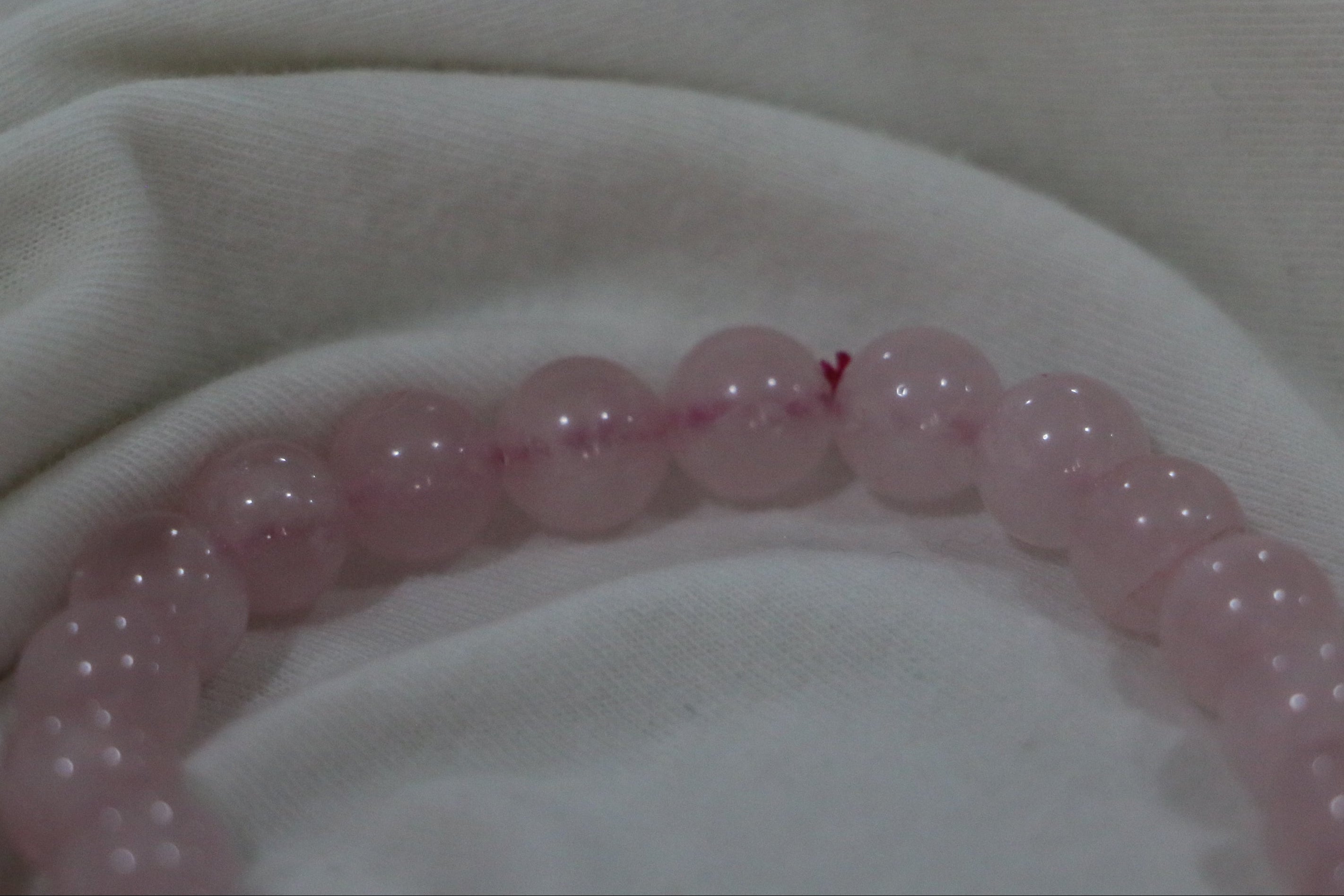 Pink beaded bracelet on a light fabric background