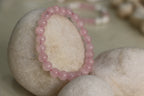 Pink beaded bracelet on a stone surface
