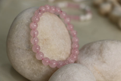 Pink beaded bracelet on a stone surface