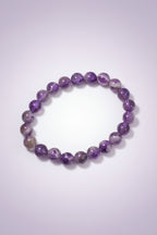 Purple beaded bracelet on a textured surface